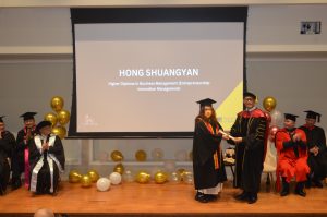 Dr Alan Go presenting a graduation certificate to a Hanbridge Institute graduate during Graduation 2025